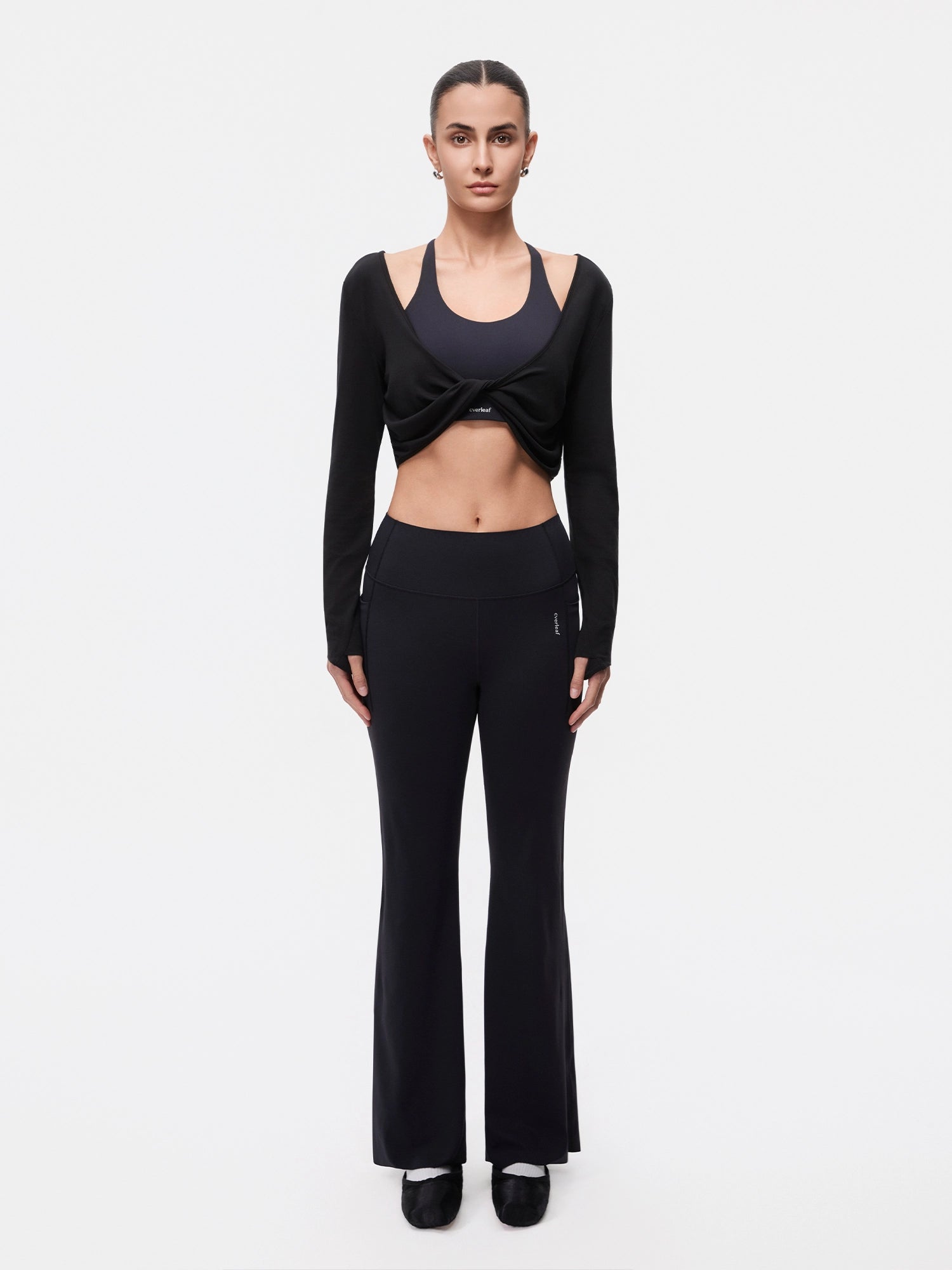 Image of Model wearing the Ebony Black reversible ballet twist cardigan, full-body front view