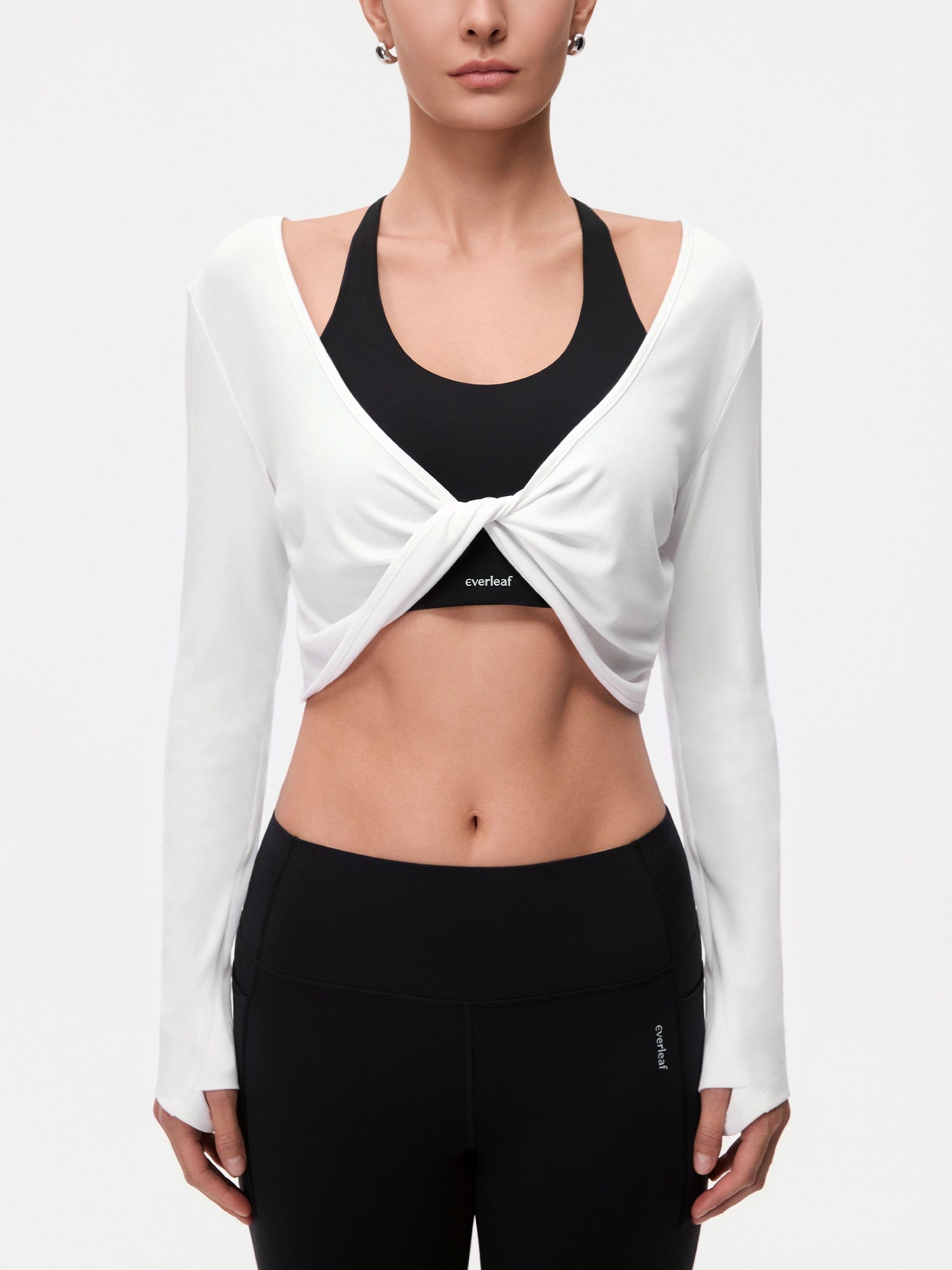 Image of Model wearing the Cloud White reversible ballet twist cardigan, half-body front twist detail view.