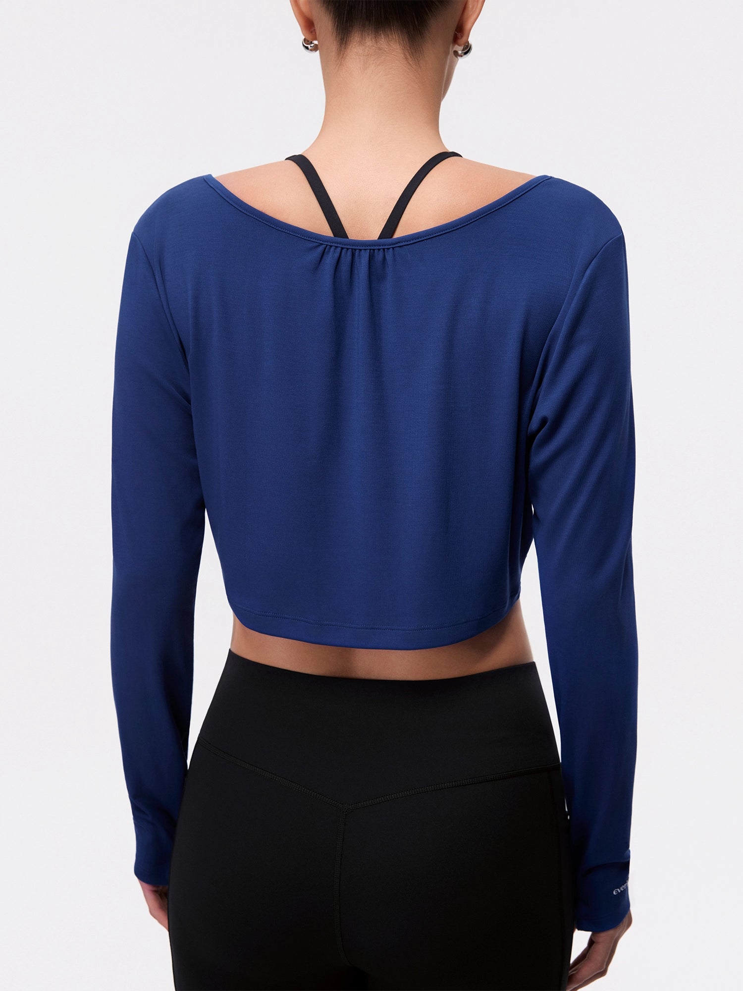 Image of Model wearing the Estate Blue Reversible Ballet Twist Cardigan, half-body back view.