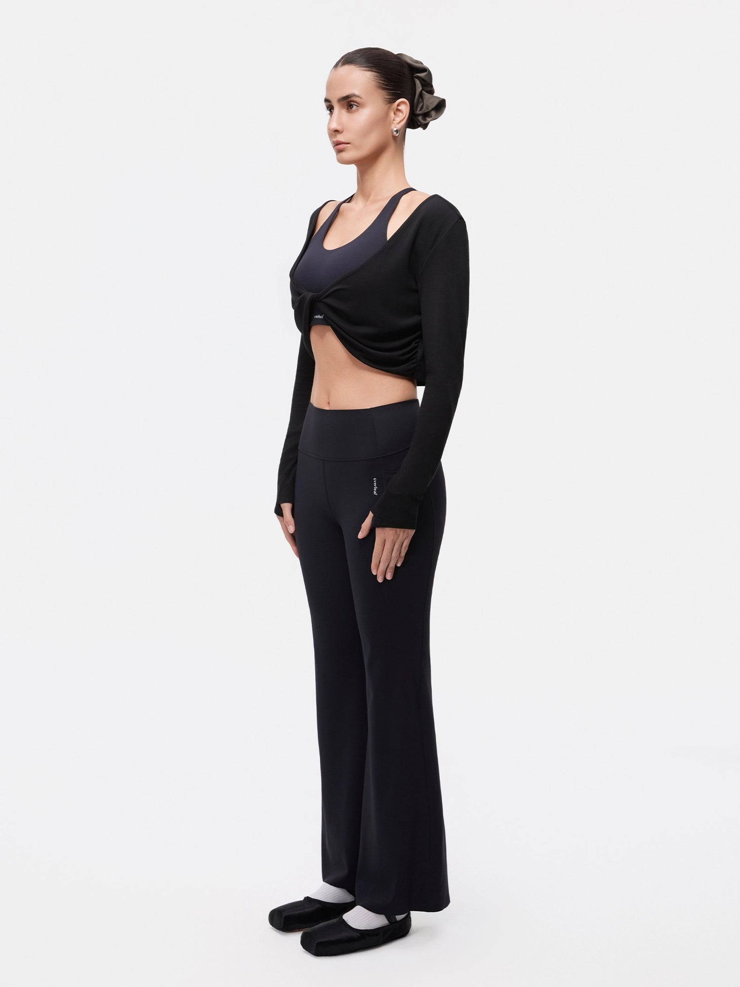 Image of Model wearing the Estate Blue reversible ballet twist cardigan, full-body side view.