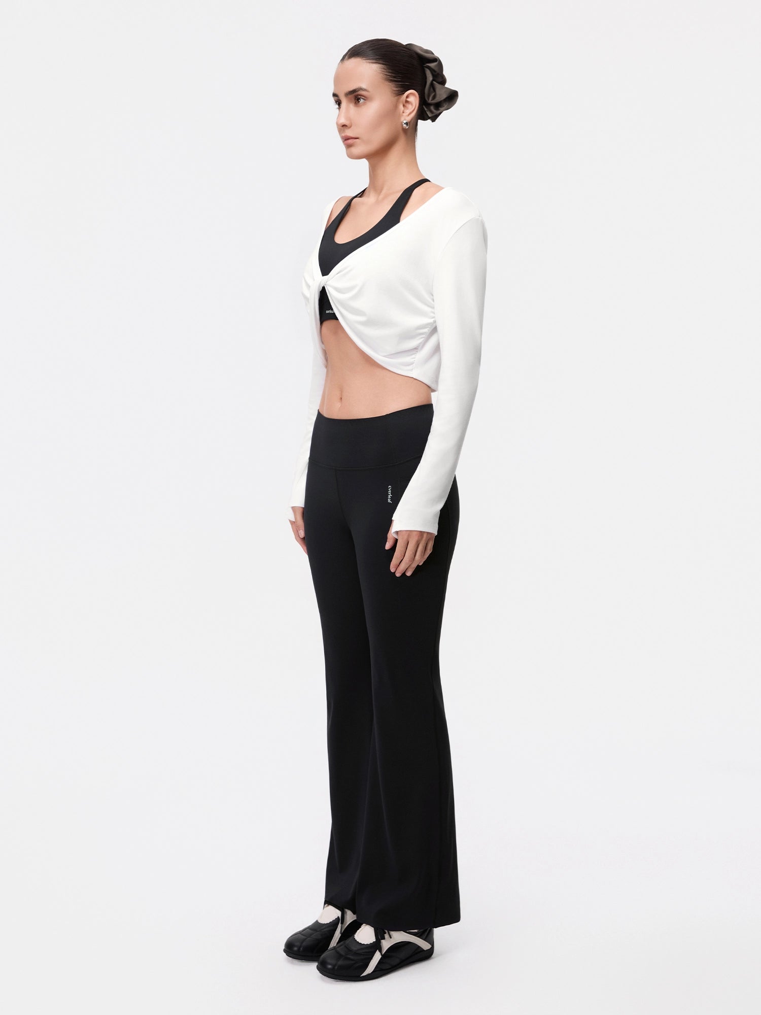 Image of Model wearing the Cloud White reversible ballet twist cardigan, full-body side view.