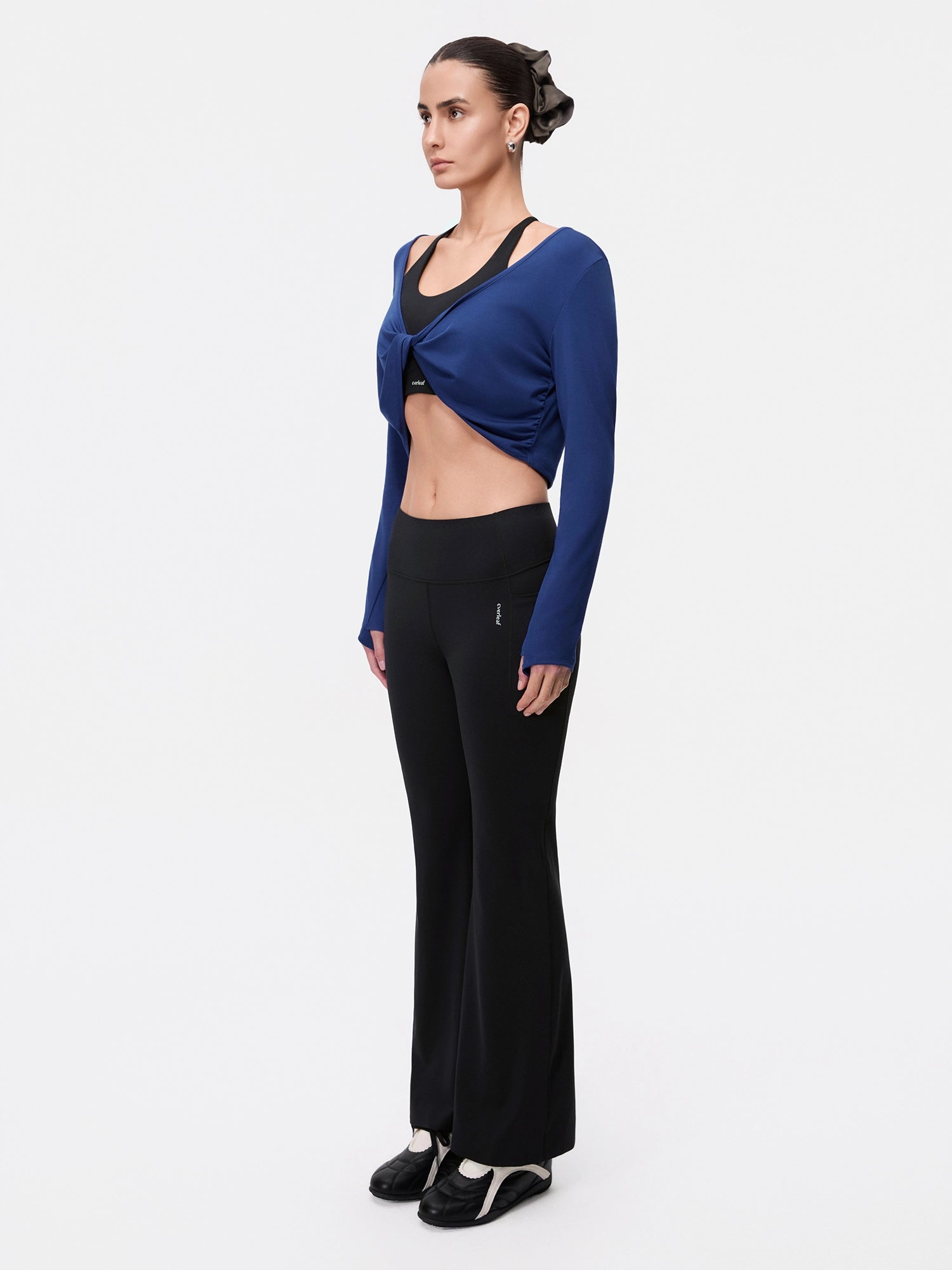 Image of Model wearing the Estate Blue Reversible Ballet Twist Cardigan, full-body side view.