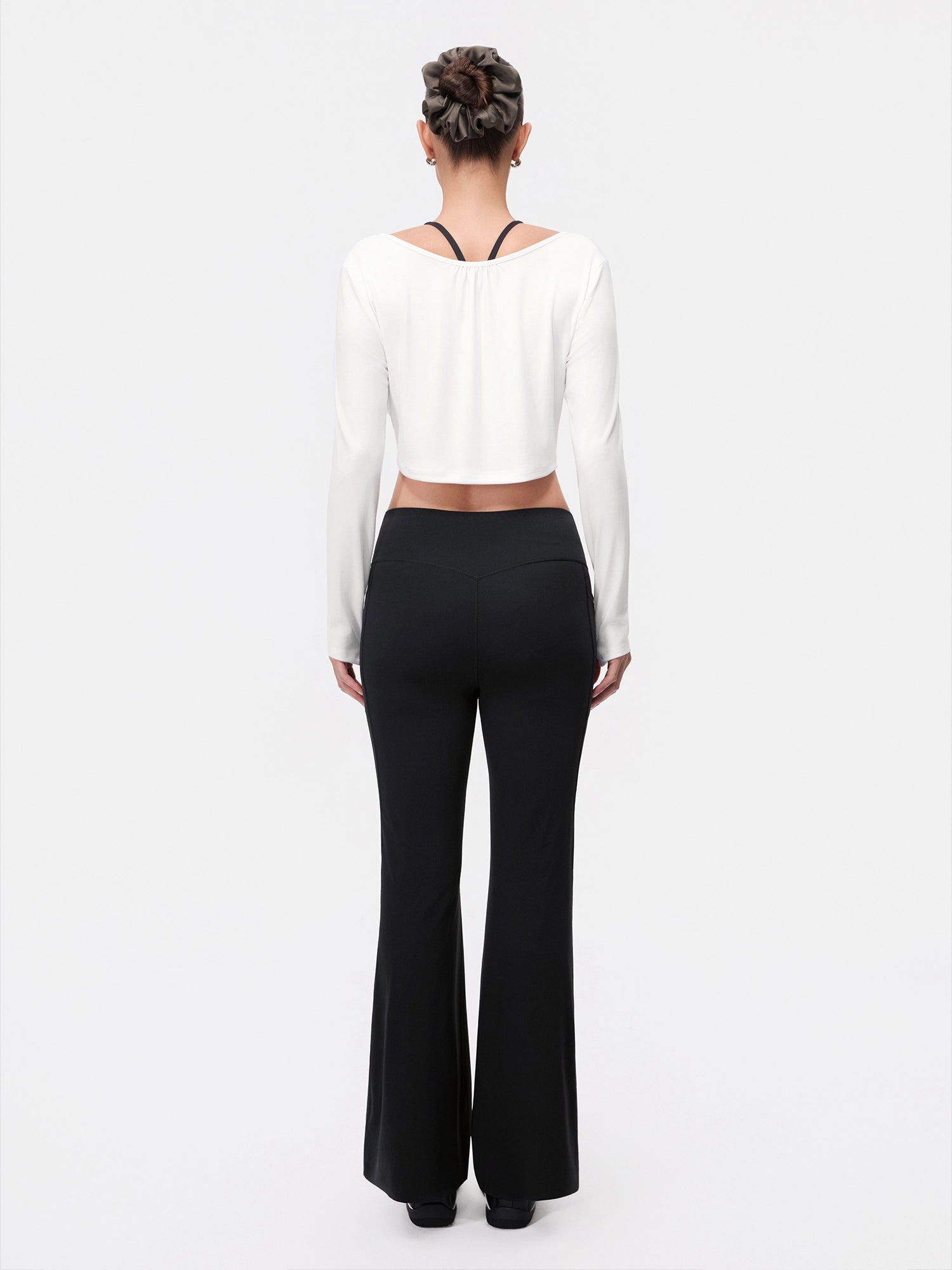 Image of Model wearing the Cloud White Reversible Ballet Twist Cardigan, full-body back view.