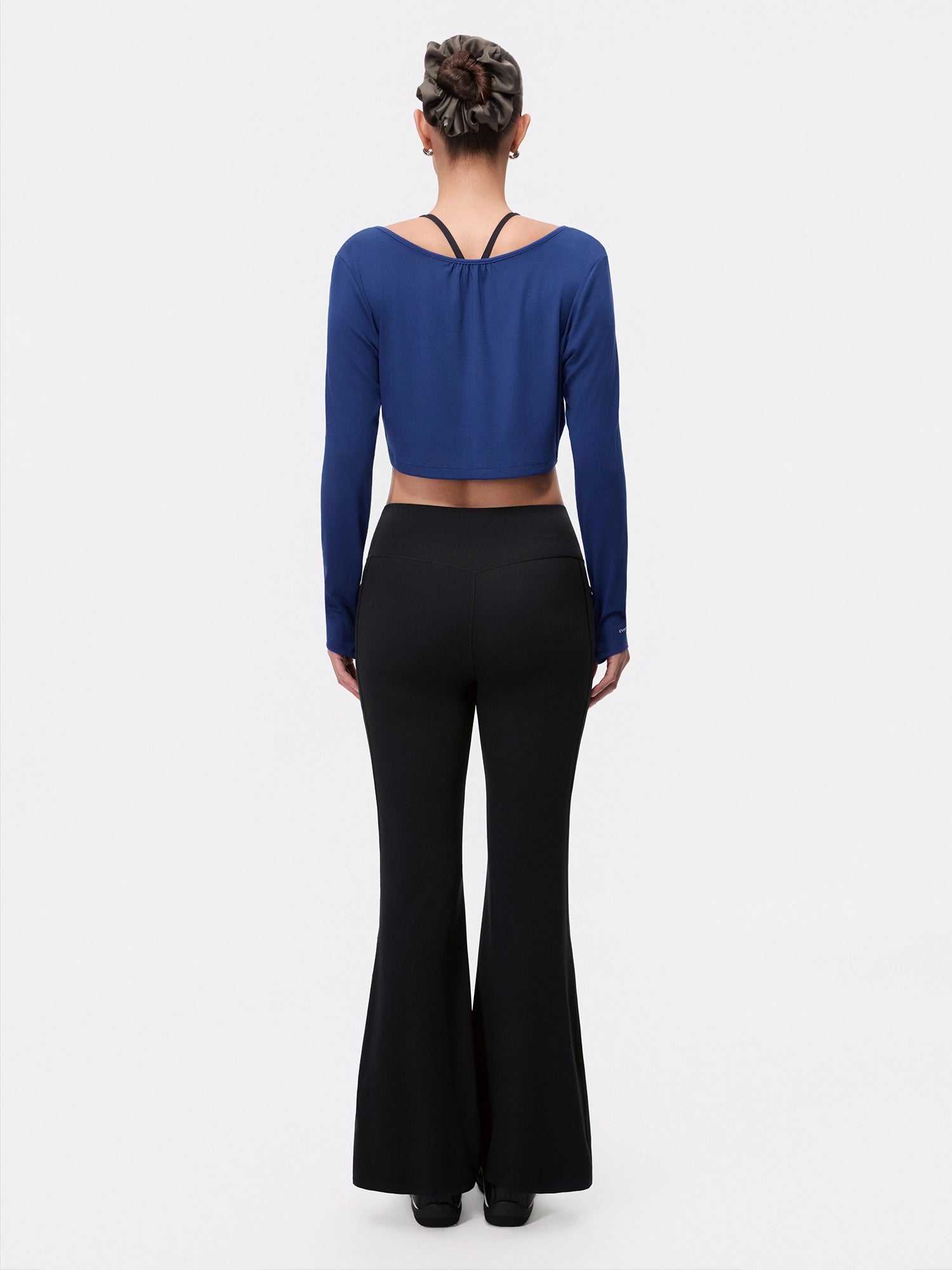 Image of Model wearing the Estate Blue Reversible Ballet Twist Cardigan, full-body back view.